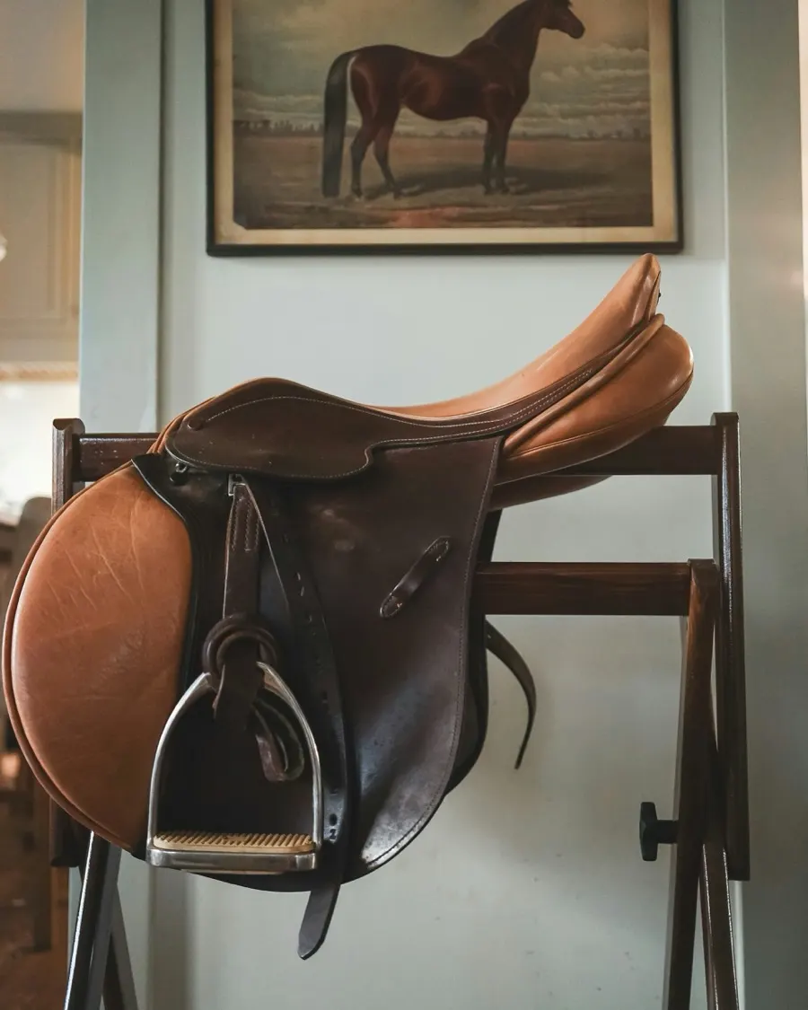 A saddle resting on a rack in a tack room